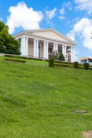 VOLGOGRAD, RUSSIA - June 25, 2017: The ancient building of musical theater with columns against the background of a green lawn with a grass and the blue sky in the summerのeditorial素材