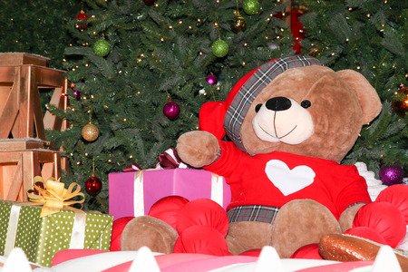 VOLGOGRAD, RUSSIA - December 07, 2017: The big teddy bear sits near a New Year tree and gifts in the foyer "Shopping center" in Voroshilovsky district of the city of Volgogradのeditorial素材