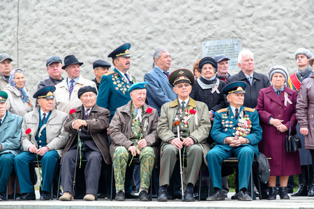 VOLGOGRAD, RUSSIA - October 15, 2017: Group of old military pensioners in a military uniform, awards and medals sit on chairs with a tack flower のeditorial素材