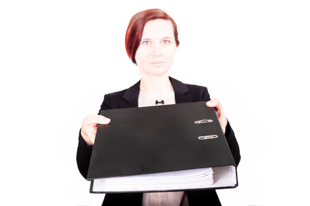 The business woman the brunette in a jacket stretches the folder with documents, on the isolated white background forward. A portrait on a beltの写真素材