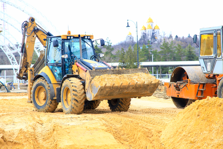VOLGOGRAD, RUSSIA - April 23, 2018: The yellow tractor in work earthwork with sand, at construction...