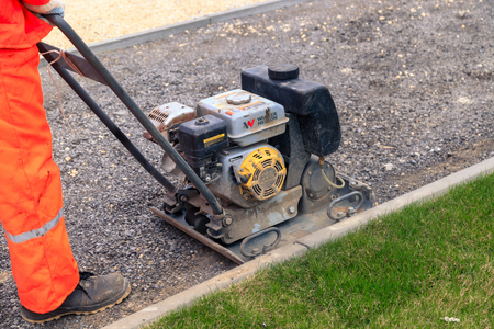 VOLGOGRAD, RUSSIA - April 23, 2018: The worker in orange special clothes repairs asphalt, a roadworkのeditorial素材