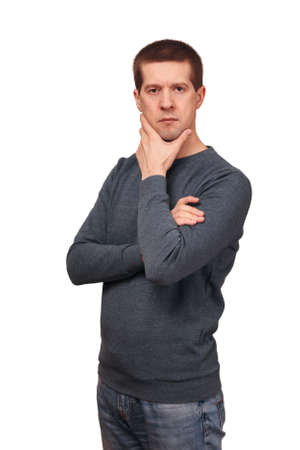 Thoughtful caucasian the man is dressed in long sleeved t-shirt, jeans and holds a hand about the headの写真素材