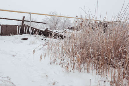 VOLGOGRAD, RUSSIA - 27 December, 2018: The old wooden warped fence in the winter in snowのeditorial素材