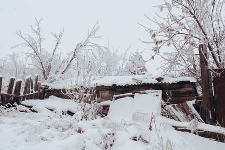 VOLGOGRAD, RUSSIA - 27 December, 2018: The old wooden warped fence in the winter in snowのeditorial素材