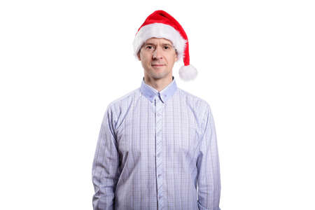 A handsome adult man looks into the camera, dressed in casual clothes, a light plaid shirt, a New Year's cap. Isolated, homogeneous backgroundの写真素材