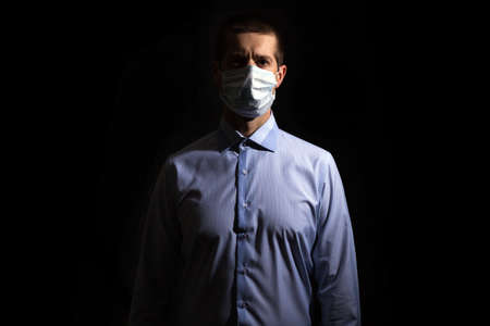 Confident serious man medical lymed, in a shirt, looking into the camera, isolated, black