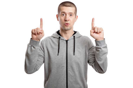 sports man in a hooded jacket, shows the index finger of both hands in the upwards. look into the...
