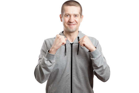 smiling joyful man, wearing a sports hooded sweatshirt, holds cams with joy. Isolated, on whiteの写真素材