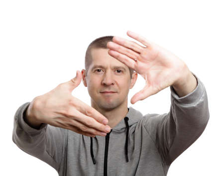 handsome man pulled forward the palm of his hands forming a frame. Dressed in sportswear. Isolated, on white. Close-upの写真素材