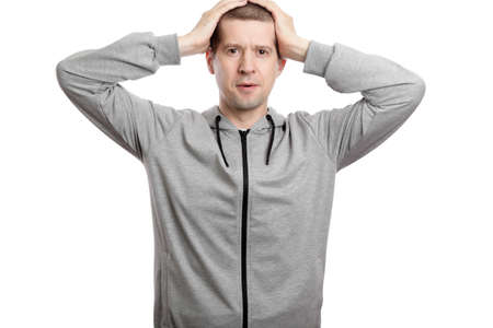 delighted man clutched his head with surprise. Dressed in sportswear. Isolated, on white