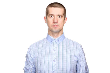 funny unusual man in a classic blue shirt, short haircut and closed mouth look into the camera. Isolated, on whiteの写真素材