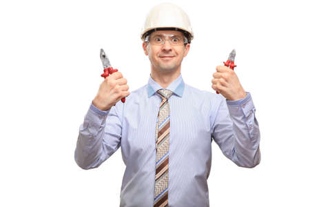 Funny man in a helmet, glasses, office shirt and tie holds hand tools, insulated, on white