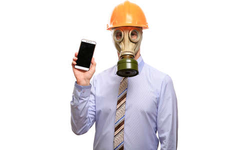 A builder in a gas mask demonstrates the gadget in his hand, helmet, shirt and tie. Isolated, on whiteの写真素材