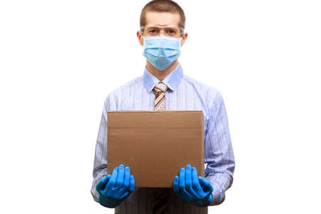 A man wearing a medical mask, glasses, rubber gloves, holding a cardboard box in front of him....