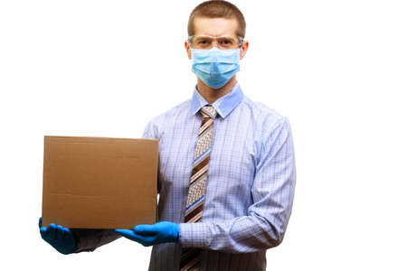 A man wearing a medical mask, glasses, rubber gloves, holding a cardboard box in his hands....