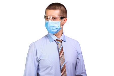 Businessman in medical mask and glasses looks asideの写真素材