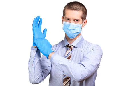Businessman in medical mask, glasses, dresses rubber glovesの写真素材