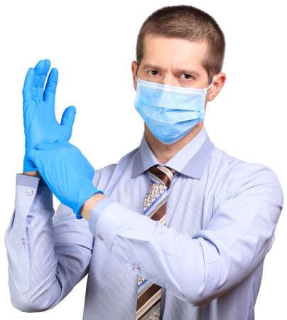 Businessman in medical mask, glasses, dresses rubber glovesの写真素材