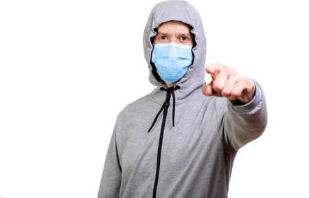 Sports man in hooded, medical mask on his face, shows finger into camera, isolated, whiteの写真素材