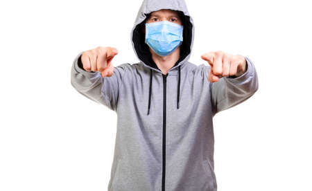 Sports man in hooded, medical mask on his face, shows finger into camera, isolated, whiteの写真素材