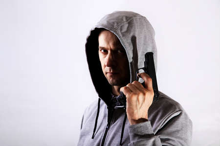Fearful man with gun and hood on his head, major planの写真素材