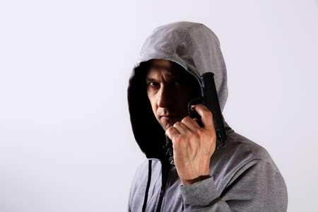Evil man with gun and hood on his head, major planの写真素材