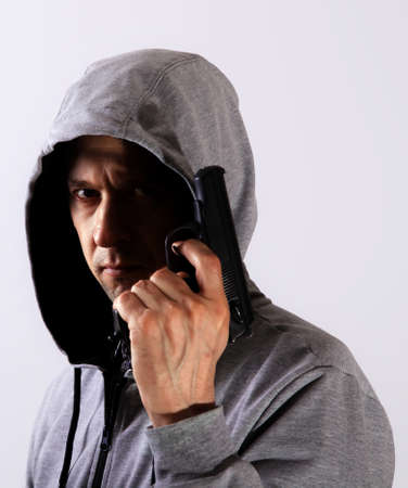 Evil man with gun and hood on his head, major planの写真素材