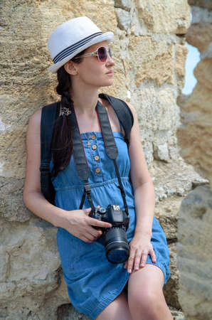 Portrait of a girl with a camera near the wallの写真素材