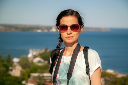 Thin girl photographer in nature, by the seaの写真素材