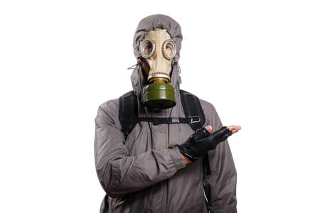 An isolated shot of a man dressed in a gas mask, a jacket with a hood, a backpack, shows the index finger of his hand to the right. On a white isolated background, the studioの写真素材