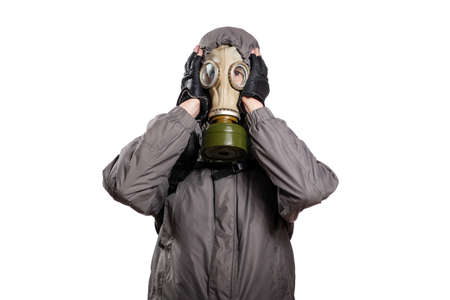 An isolated shot of a man dressed in a gas mask, a jacket with a hood, a backpack, grabbed his head with two hands out of regret and trouble. On a white isolated background, the studioの写真素材