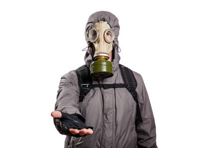 An isolated shot of a man dressed in a gas mask, a hooded jacket, a backpack, reaching out for a handshake, looking into the camera. On a white isolated background, the studioの写真素材