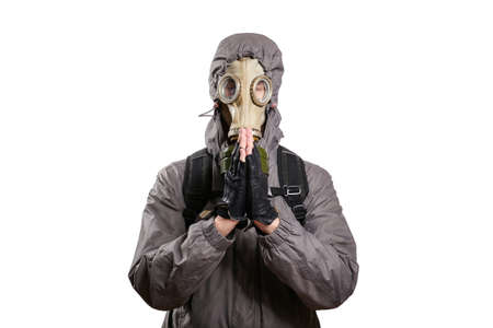 An isolated shot of a man dressed in a gas mask, a jacket with a hood, a backpack, praying closed...