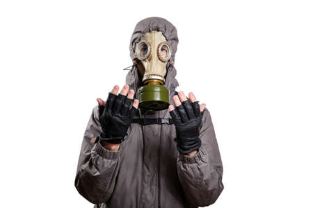 An isolated shot of a man dressed in a gas mask, a hooded jacket, a backpack, praying, with his hands tinged slightly forward and to the sides. On a white isolated background, the studioの写真素材
