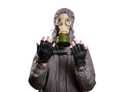 An isolated shot of a man dressed in a gas mask, a hooded jacket, a backpack, praying, with his hands tinged slightly forward and to the sides. On a white isolated background, the studioの写真素材