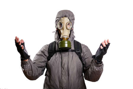 An isolated shot of a man dressed in a gas mask, a hooded jacket, a backpack, praying, with his hands tinged slightly forward and to the sides. On a white isolated background, the studioの写真素材