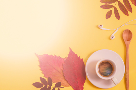 Coffee with herbarium and headphones on yellow background. Autumn. Flat lay. Top view. Copy spaceの写真素材