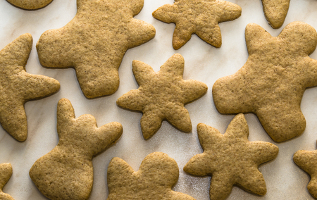 Home-baked gingerbread on a kitchen surface with a baking sheet and baking paper - Christmas concept with home-baked cookies in the kitchen.の写真素材
