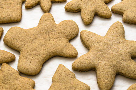 Home-baked gingerbread on a kitchen surface with a baking sheet and baking paper - Christmas concept with home-baked cookies in the kitchen.の写真素材