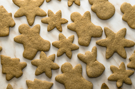 Home-baked gingerbread on a kitchen surface with a baking sheet and baking paper - Christmas concept with home-baked cookies in the kitchen.の写真素材