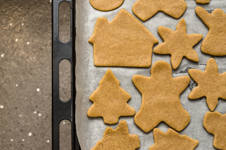 Home-baked gingerbread on a kitchen surface with a baking sheet and baking paper - Christmas concept with home-baked cookies in the kitchen.の写真素材