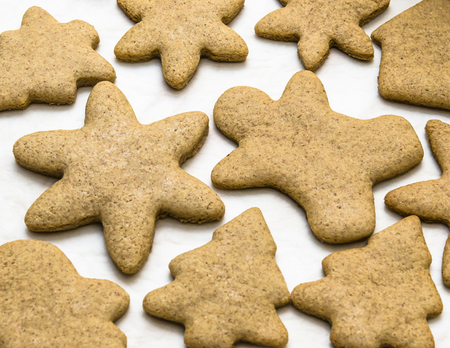 Home-baked gingerbread on a kitchen surface with a baking sheet and baking paper - Christmas concept with home-baked cookies in the kitchen.の写真素材