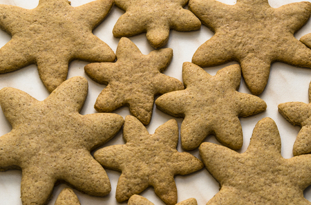 Home-baked gingerbread on a kitchen surface with a baking sheet and baking paper - Christmas concept with home-baked cookies in the kitchen.の写真素材