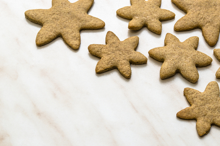 Home-baked gingerbread on a kitchen surface with a baking sheet and baking paper - Christmas concept with home-baked cookies in the kitchen.の写真素材
