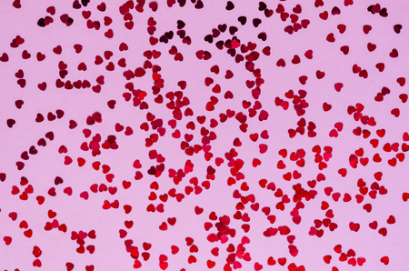 Holographic red hearts on trendy pink background. Festive backdrop. Top viewの写真素材