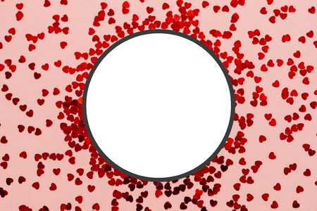 Holographic red hearts on trendy coral background. Festive backdrop. Top view. Copy spaceの写真素材