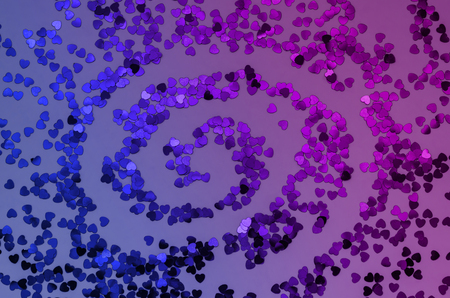 Holographic hearts on trendy purple, pink and blue background spiral shaped . Festive backdrop. Top viewの写真素材