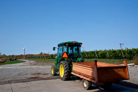 A tractor in the vineyard with rows of wine grapes in the field.の写真素材