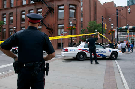 Toronto, Ontario, Canada - 06/04/2010: POLICE LINE BARRIER TAPE and police cars set up to block the...
